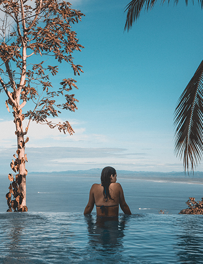 Woman in pool enjoying WorldHotels Rewards